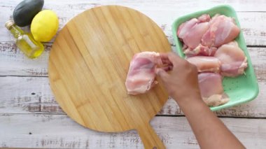 Çiğ tavuk butları pişmeye hazır ve taze malzemelerle birlikte.