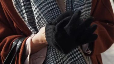 Kadın elleri soğuk bir kış gününde sıcak eldivenler giyer.