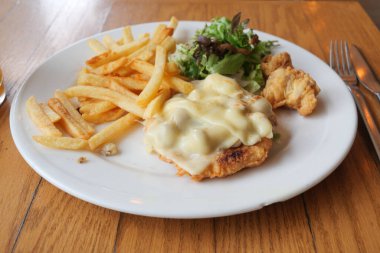 Kızarmış tavuk, altın kızartma ve taze salata içeren çok cazip bir yemek.