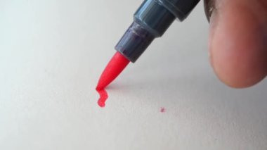 Siyah işaret kağıdın üzerine mavi çizgi çiziyor 