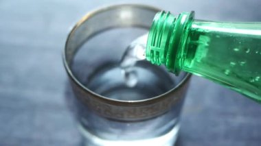 Bir şişeden bardağa meşrubat dökmek .