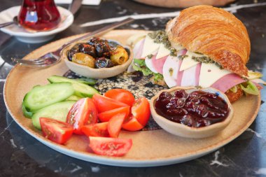 Lüks bir kahvaltı, gevrek bir kruvasan, taze meyveler ve tuzlu soslar. Afiyet olsun