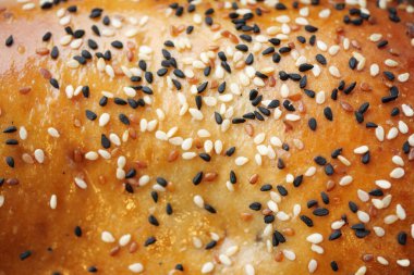 Üzerinde siyah ve beyaz susam tohumlarının hoş bir karışımı olan taze pişmiş ekmek.