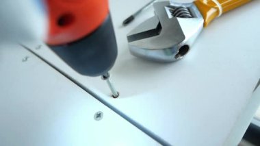 DIY araçlarının etkinliği ve hassasiyeti vurgulanarak, bir matkap ve anahtar eylemde yakın plan görüntüsü