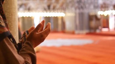 Başörtülü Müslüman genç kadın camide dua ediyor