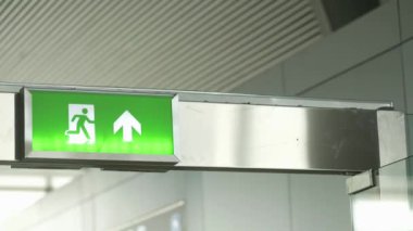 Modern bir ortamda yön gösteren açık bir acil çıkış işareti