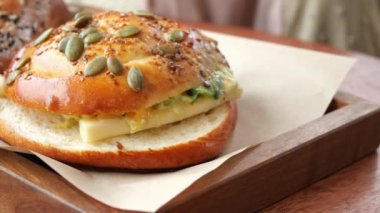 Lezzetli, sıcak bir simit, çeşitli tohumlarla süslenmiş ve kremayla doldurulmuş.