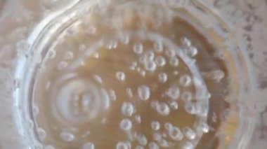 Yakından bakınca, bir bardakta temiz bir sıvının içinde güzel kabarcıklar oluşuyor.