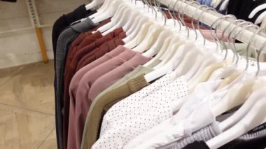 Çok güzel düzenlenmiş bir elbise rafında şık elbiseler sergileniyor.