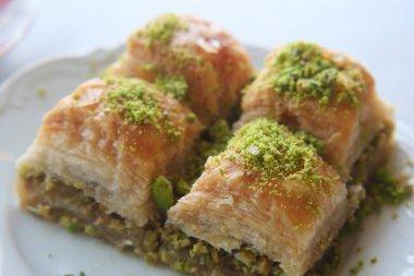 Şam fıstığı kırıntılarıyla serpiştirilmiş otantik baklava dilimlerinin tadını çıkarın.