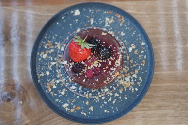 Taze böğürtlen ve fındık içeren bir gurme tatlısının sanatsal gösterisi.