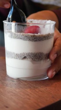 Granola ve taze çilek katmanlı besleyici chia tohumu pudingi, sağlıklı bir atıştırmalık için mükemmel..