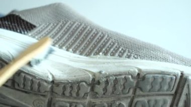 Kirli ayakkabıları fırçayla yıkayan adam