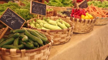 Bir çiftçi pazarında sepetlerde zarif bir şekilde sergilenen canlı taze sebzeler.