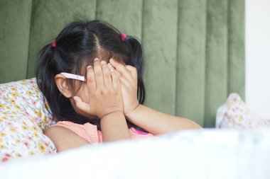 Genç bir kız ellerini şakaya vurarak yüzünü kapatıyor, keyifli bir anın tadını çıkarıyor..