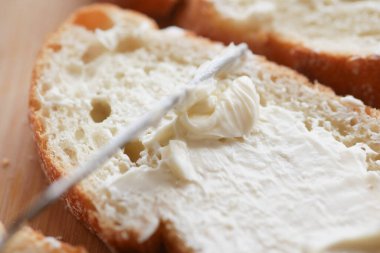  Taze tereyağı ekmeğe yayılıyor. ,