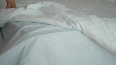 Yumuşak çarşaflar ve buruşuk battaniyelerle süslenmiş davetkar bir yatağın güzel huzurlu manzarası.