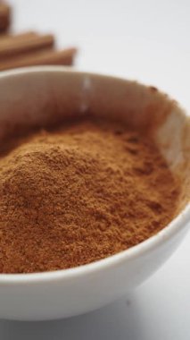 tarçın ve beyaz zemin üzerine toz tarçın