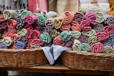 Yoğun bir pazarda, dokuma sepetlerde çok güzel sarılmış havlular var.