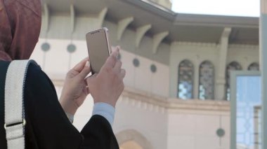 Kibar giyinmiş bir kadın, mimari güzelliğin çarpıcı bir fotoğrafını çekiyor.