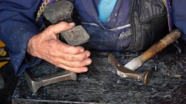 Becerikli bir zanaatkar, sanatını sergilemek için gerekli aletleri bir atölyede güvenle bulundurur.