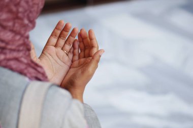 Başörtülü Müslüman genç kadın camide dua ediyor