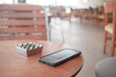 Kafe masasında akıllı telefonu unut, akıllı telefonu kaybet. ,
