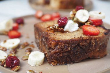 Taze meyve ve fındıkla kaplı ıslak muzlu ekmeğin tadını çıkar. Atıştırmalıklar için idealdir.