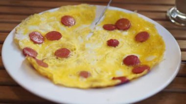 Ağız sulandıran, lezzetli bir omlet. Taze dilimlenmiş sosislerle güzelce süslenmiş.
