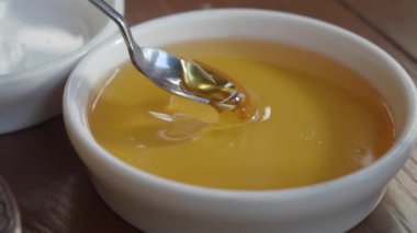 Gümüş kaşıklı bir kase altın bal, yemek ve tatlıları geliştirmek için mükemmel.