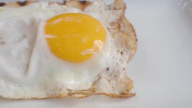 Mükemmel kızartılmış bir yumurtanın yakın plan görüntüsü canlı ve parlak sarı bir sarıyı gösteriyor.