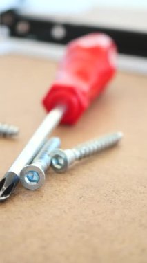 Bu, tahta bir yüzey üzerinde vidaların yanı sıra bir tornavida ayrıntılı bir perspektif olduğunu