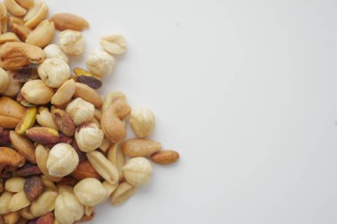 Temiz beyaz bir yüzeye sergilenen çeşitli fındıklar sağlıklı atıştırmalıklar sergiliyor..