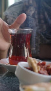 Geleneksel Türk çayını beyaz masada içen kadın 