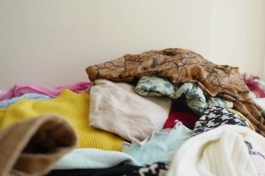 Düzensiz ama büyüleyici bir giysi yığını. Kapalı bir ortamda güzelce sergileniyor.