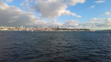 Istanbuls sularının feribotlarla dolu nefes kesen manzarası berrak, mavi bir gökyüzünün altında süzülüyordu.