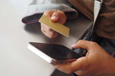  Kadınlar ellerinde kredi kartıyla internet üzerinden akıllı telefon alışverişi yapıyorlar..