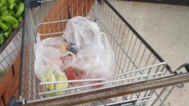Canlı, taze meyve ve sağlıklı sebzelerle dolu bir market arabası.