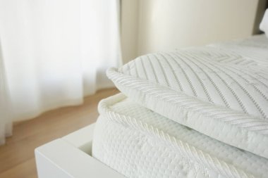 Beyaz ortopedik yataklı bir oda.