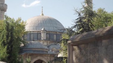 Güzel bir cami kubbesi yeşillik ve tarihi mimariyle çevrili, huzur yaratıyor.