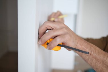 Duvarı mezurayla ölçen adam. .