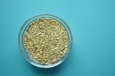 Kurumuş kekliklerle dolu güzel bir kase canlı mavi bir arkaplan üzerine kuruludur.