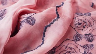 Bu narin pembe ipek kumaş her yerinde güzel ve karmaşık siyah gül tasarımları sergiliyor.