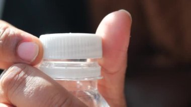 Plastik bir su şişesinin kapağını aç. .