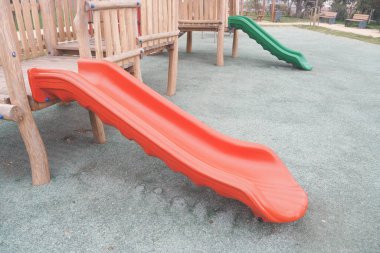 İki renkli slayt, çocuklar için eğlence ve aktiviteler için tasarlanmış canlı bir oyun parkında.