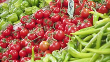 Yerel bir markette taze domates ve yeşil biberlerden oluşan canlı ve renkli bir çeşitlilik.