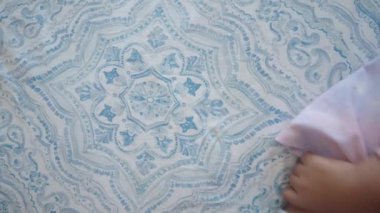 Küçük bir kız çoraplarını çıkarmaya çalışıyor. ,