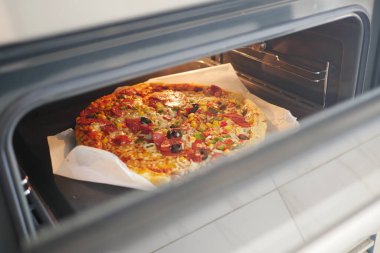 Çeşitli malzemelerle dolu bir tavada dolu bir pizza. Lezzetli bir fast food yemeği..
