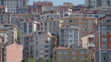 Hareketli ve hareketli bir şehir ortamında renkli konut binalarının yer aldığı bir manzara.