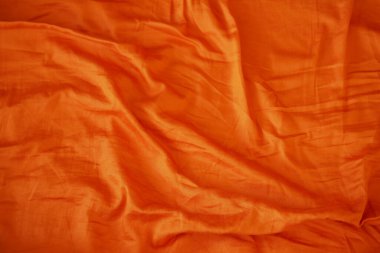 Turuncu ipek kumaş zarif tasarım projelerini geliştirmek için eşsiz kırışıklık detaylarına sahiptir.